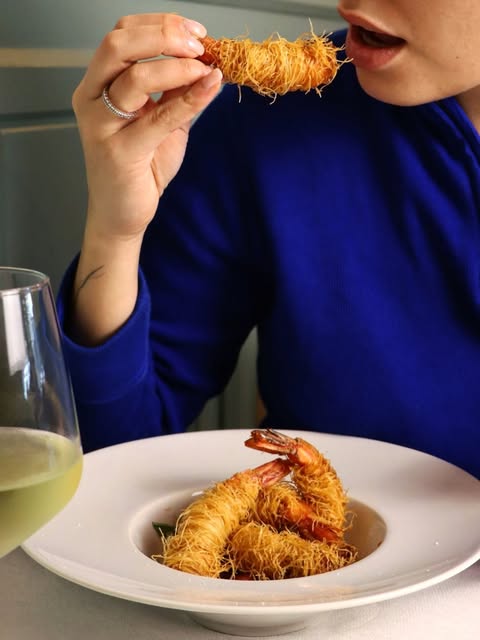 Cliente assaggia gamberi in crosta croccante di kataifi all'Osteria Marconi